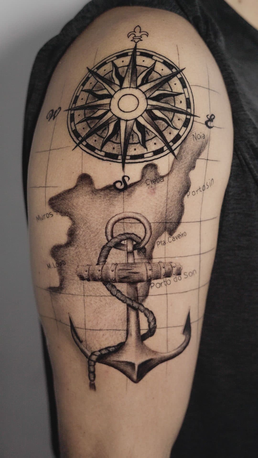 Tatuaje de una rosa de los vientos y un ancla sobre un mapa de la costa