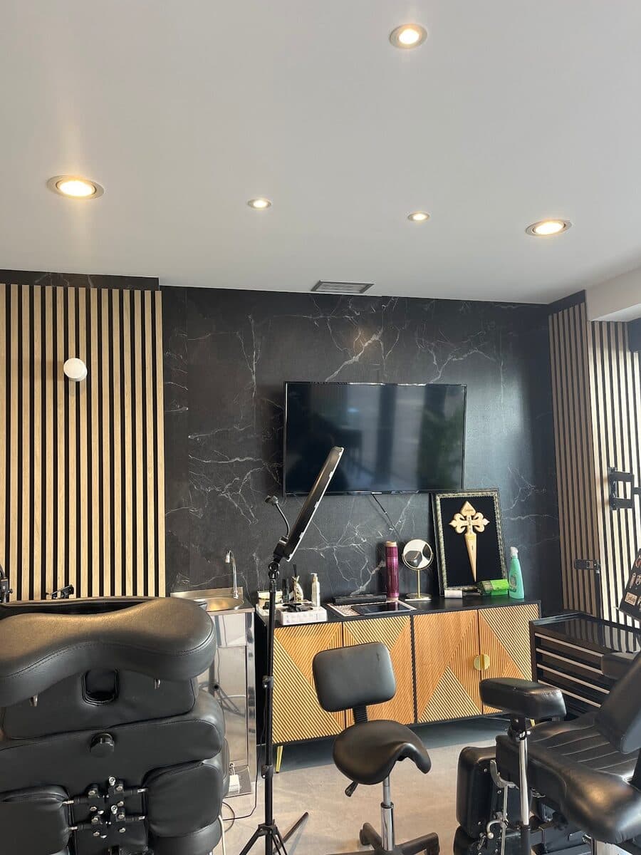 Sala del estudio Velvet con mármol negro, listones de madera y camillas de tatuaje